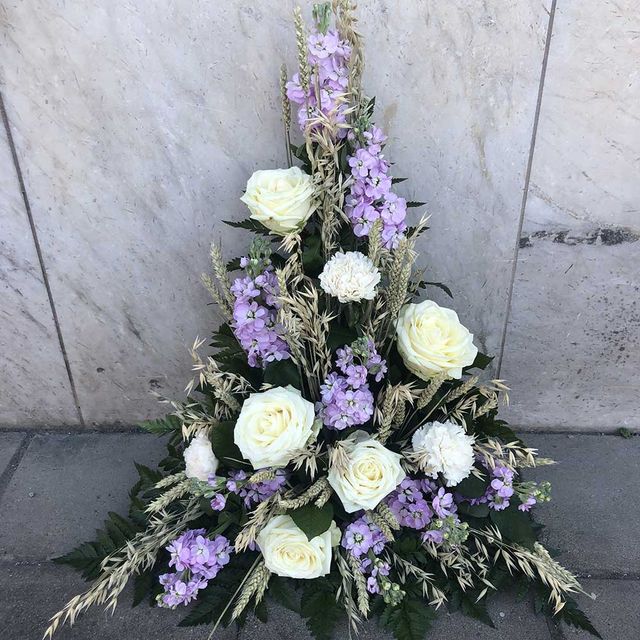 Ljuslila blommor med vita rosor till begravning