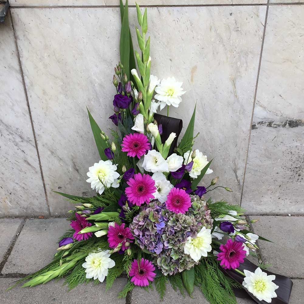 Vita, lila och rosa blommor begravning